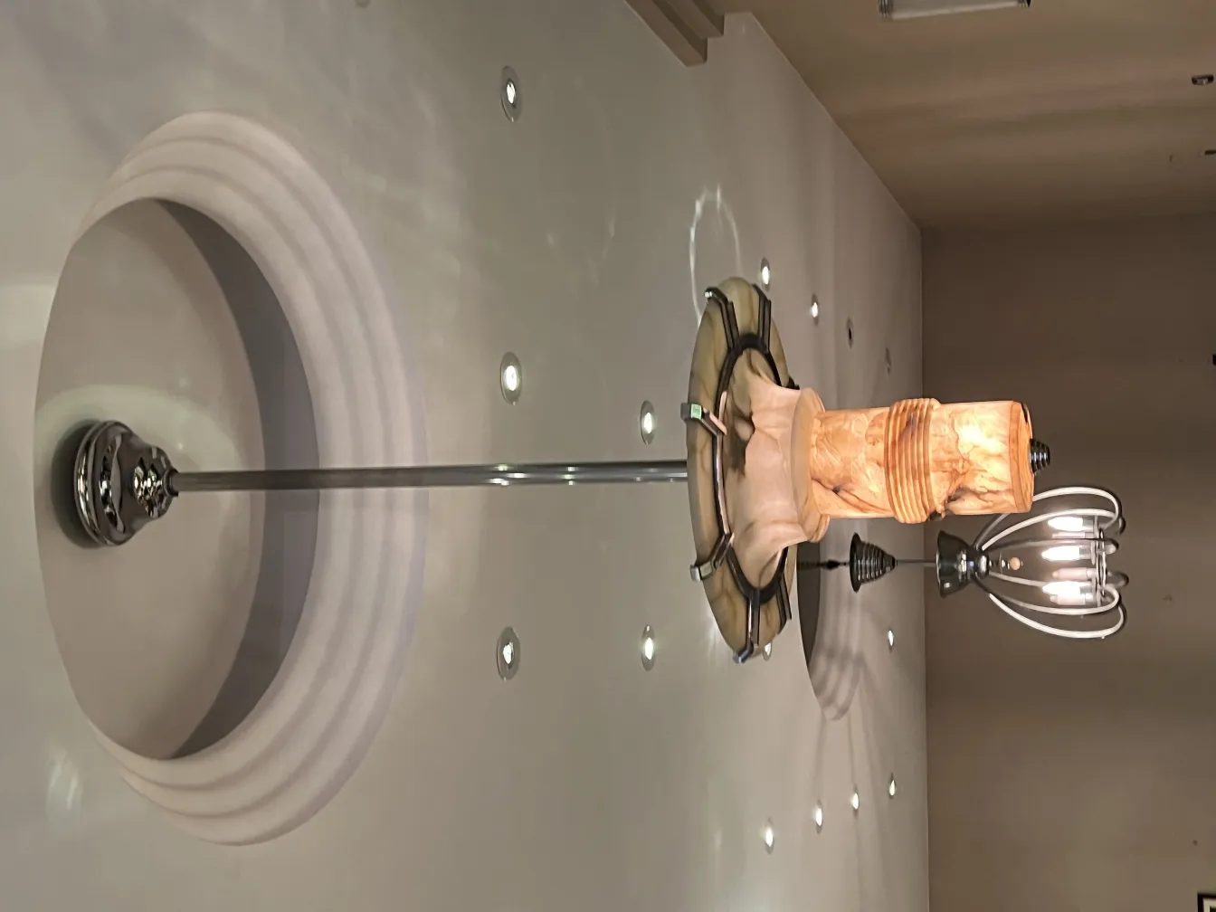 Lustre ancien avec un design unique, entouré d'un éclairage d'ambiance doux.