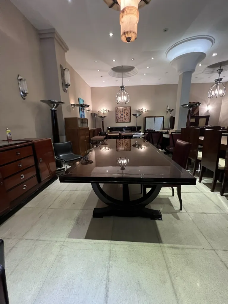 Lámpara de techo antigua suspendida en un comedor elegante con una mesa grande