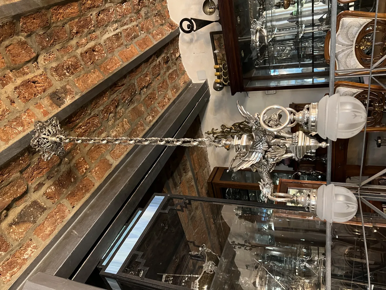 Lampada a sospensione antica con basi decorative in un ambiente elegante.