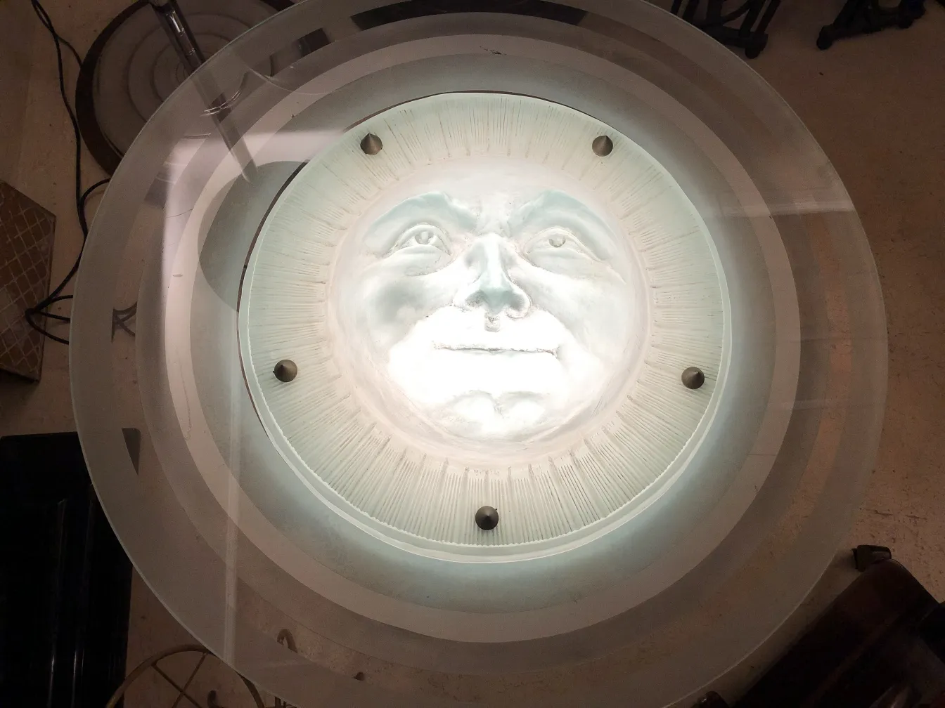 Lampada a sospensione antica con design di volto luminoso, che illumina l'ambiente.