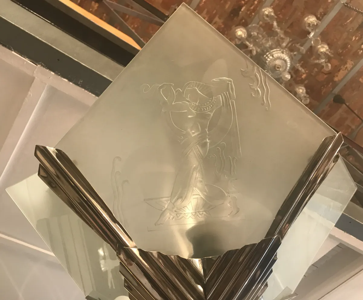 Lampada a sospensione antica con design in vetro inciso e ambiente decorativo.