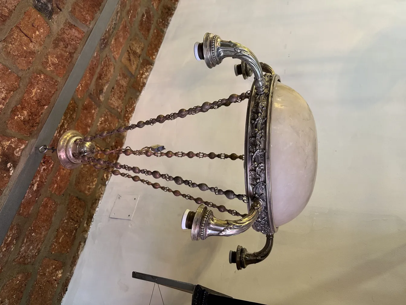 Lámpara de techo antigua en un ambiente rústico, con cadena decorativa