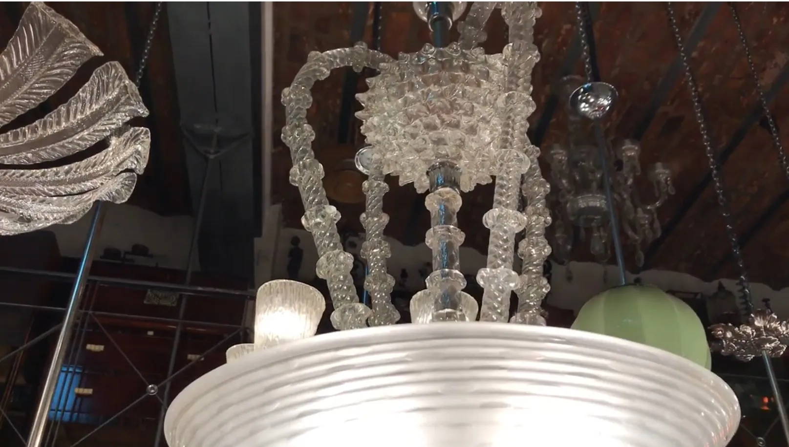 Lampada a sospensione antica con design traslucido e dettagli decorativi.