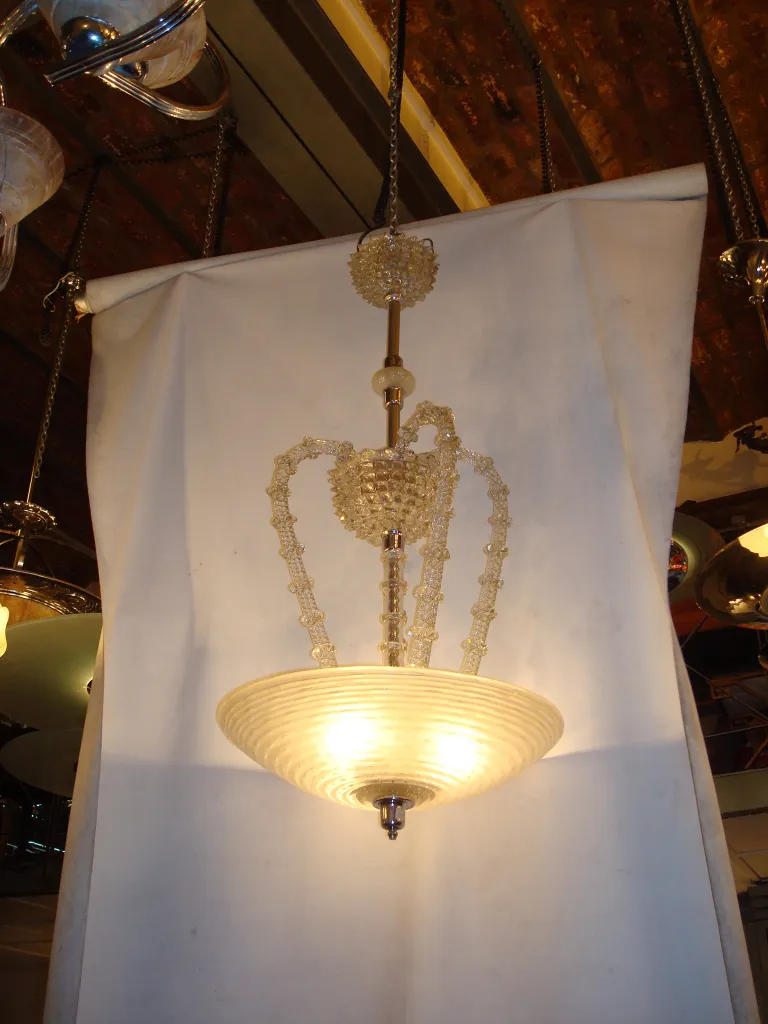 Antica lampada a sospensione con luce soffusa, stile classico, decorata con dettagli rialzati.