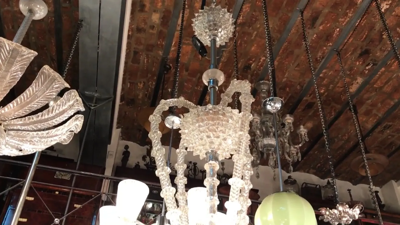 Lustre ancien en verre avec des détails élégants, illuminant une ambiance chaleureuse.