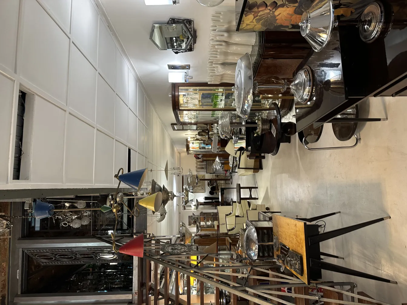 Lámpara de techo antigua con detalles coloridos en una tienda de antigüedades.