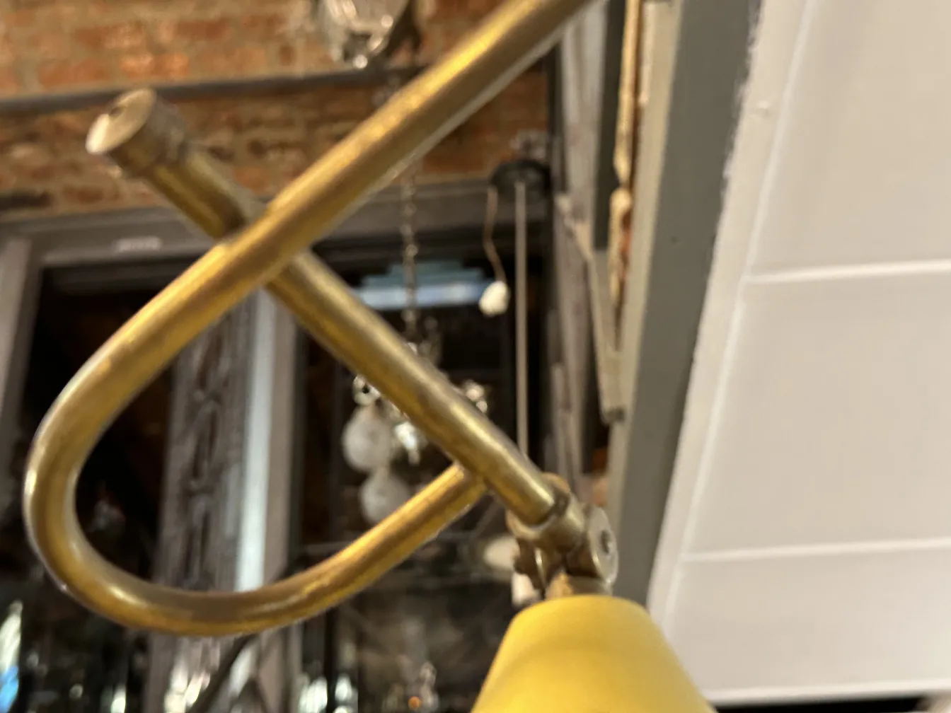 Lámpara de techo antigua con diseño curvado y cable dorado.