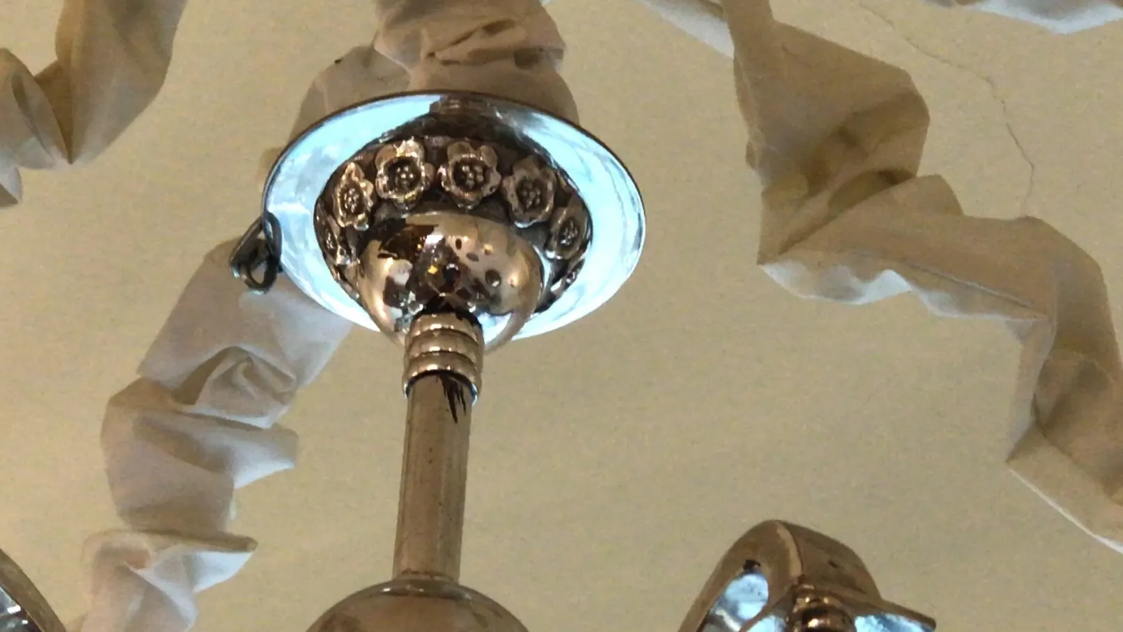 Lámpara de techo antigua brillante con detalles ornamentales, en un ambiente acogedor.