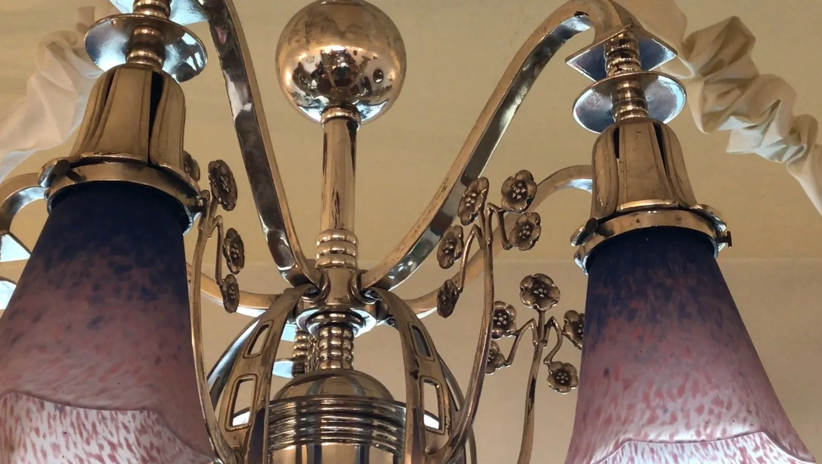 Lustre ancien avec abat-jours élégants et détails décoratifs.