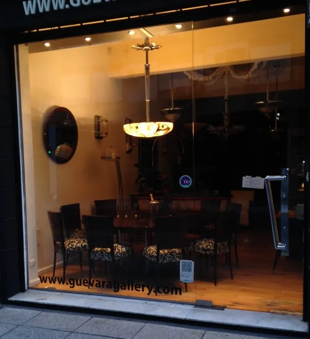 Lampada a sospensione antica con design luminoso esposta in una galleria.