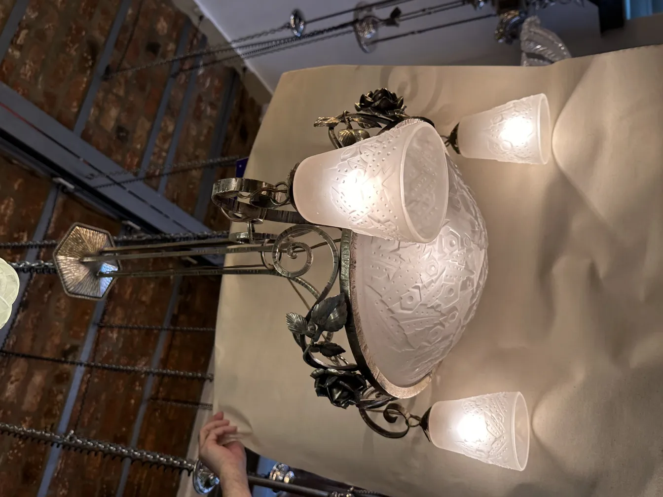 Lustre ancien avec des abat-jour en verre lumineux.