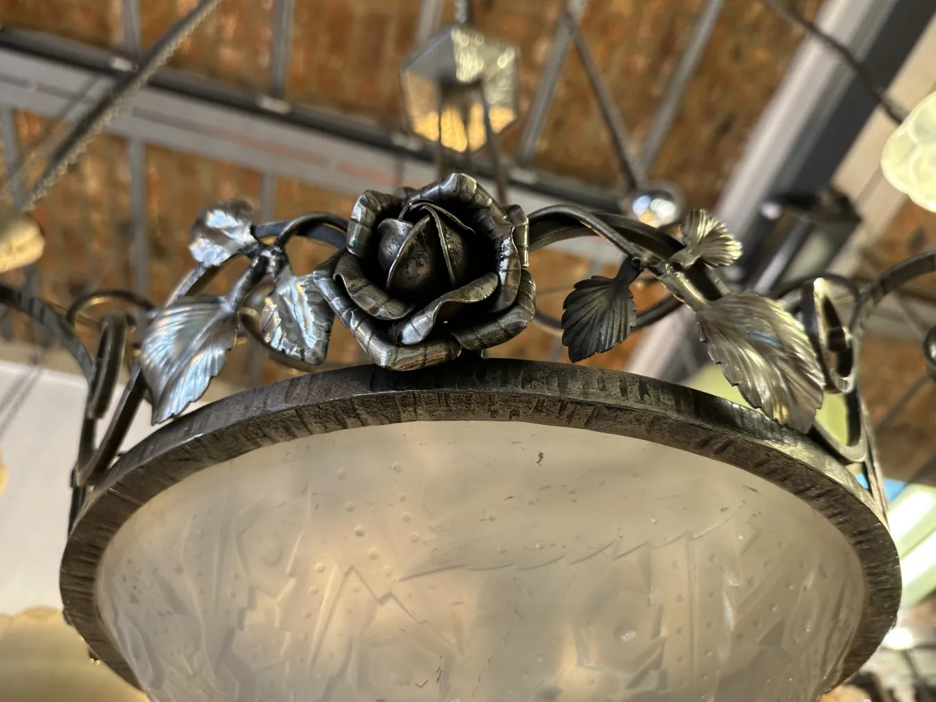 Lampada a sospensione antica con decorazione floreale, elegante, in un ambiente accogliente.