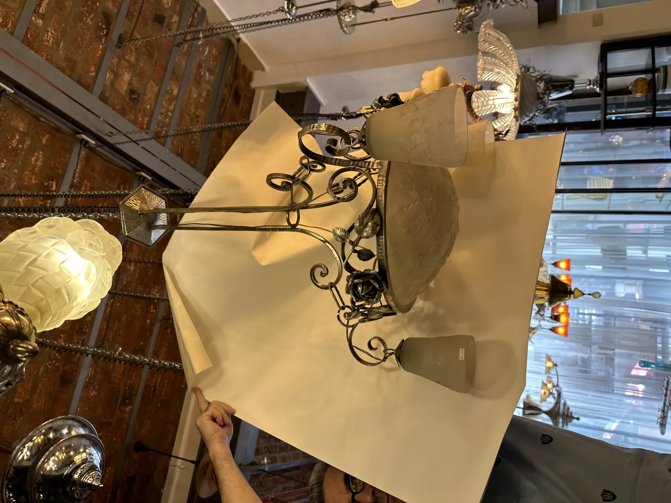 Lámpara de techo antigua con diseño elaborado y vidrios, ambiente acogedor.