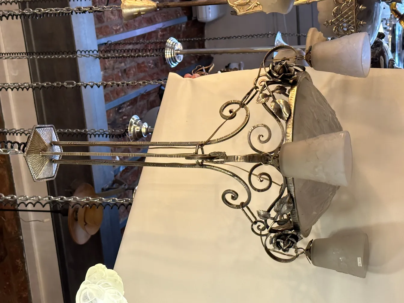 Lustre ancien avec une base décorative et des abat-jours clairs