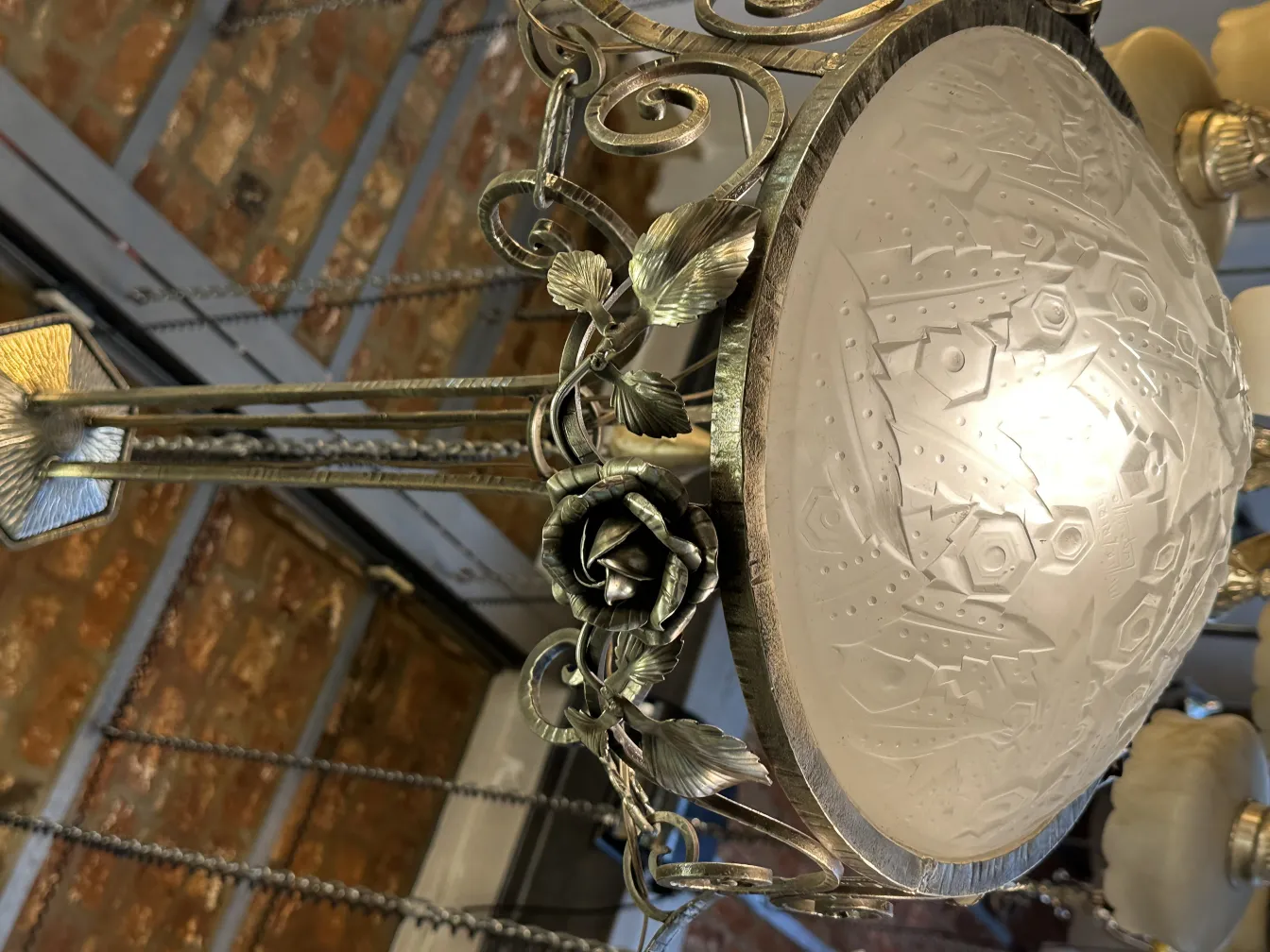 Lámpara de techo antigua con diseño decorativo de metal y cristal, en un ambiente acogedor.