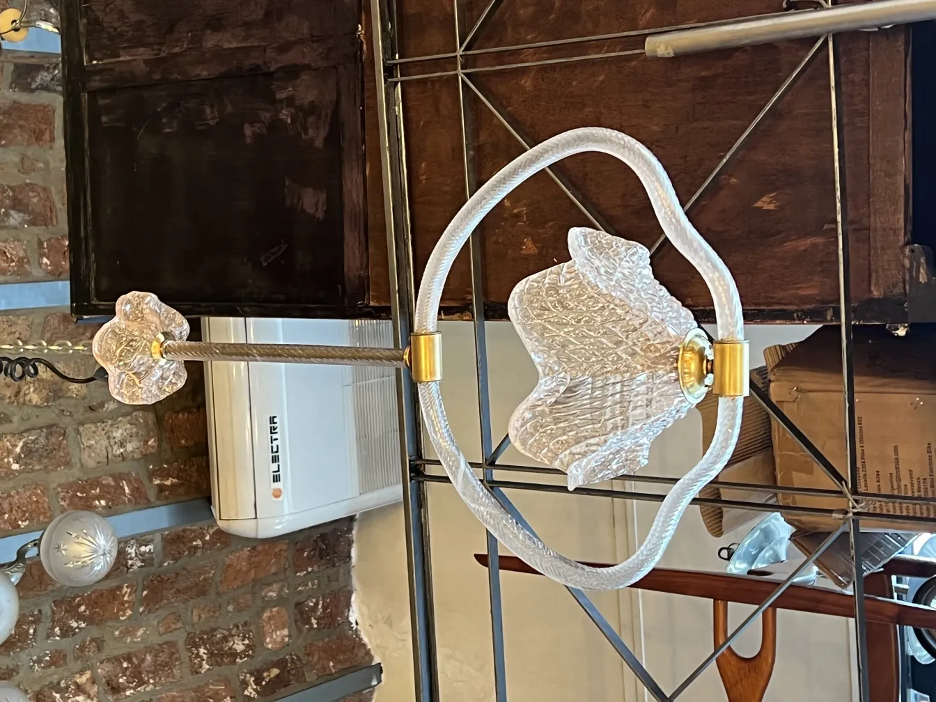 Antique hanging lamp with hexagonal design and golden details against a brick background.