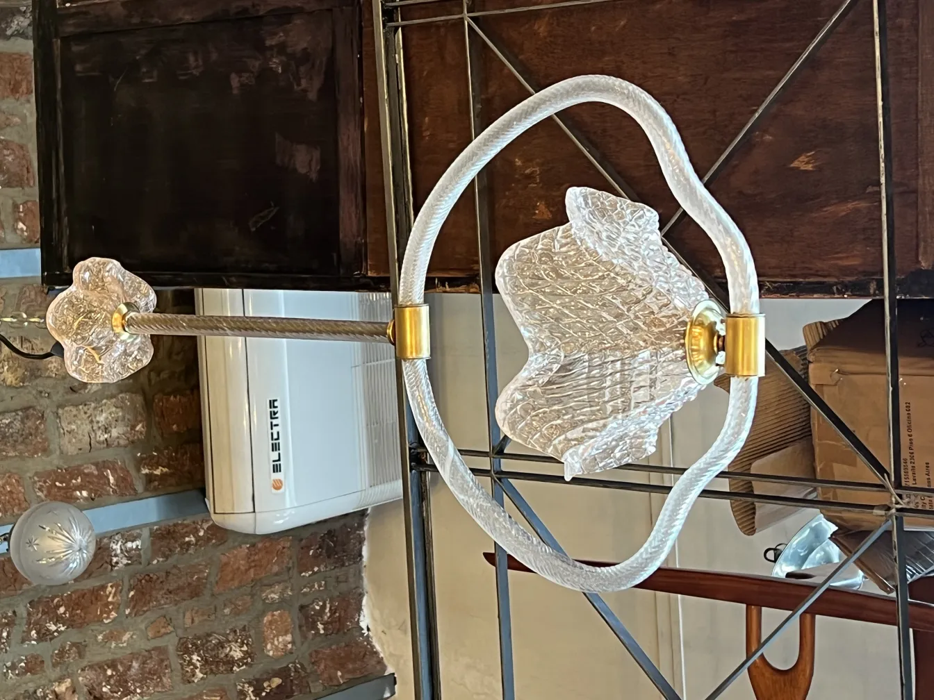 Antique hanging lamp with floral details, rustic setting.