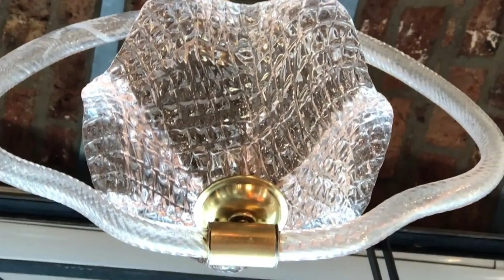 Antike Hängelampe mit durchscheinendem Schirm und goldener Basis, die eine warme Atmosphäre schafft.