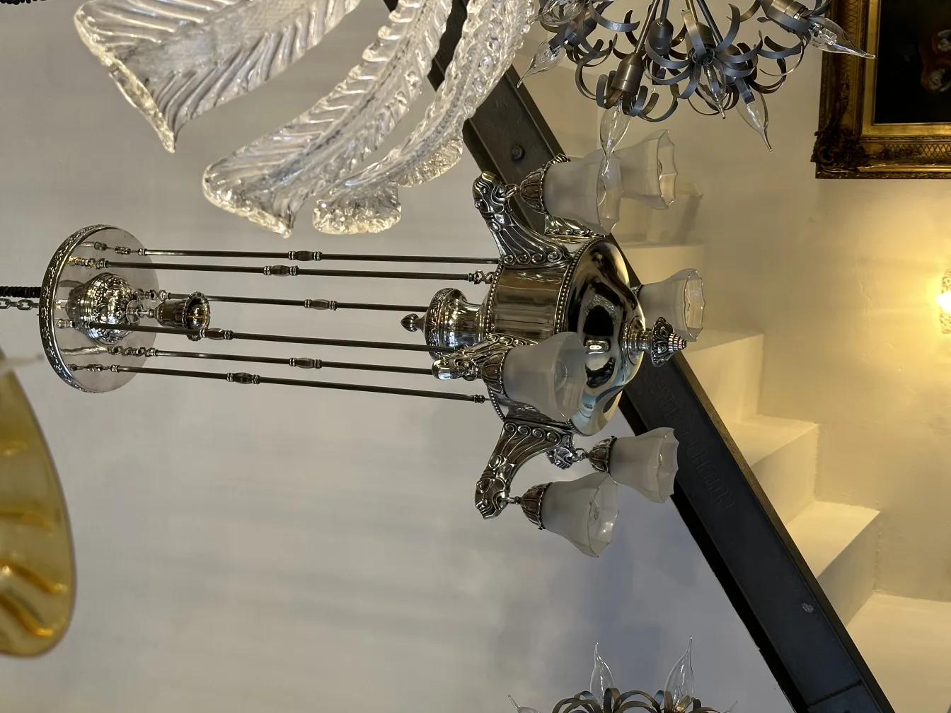 Lustre antique avec plusieurs bras décorés dans un cadre élégant.