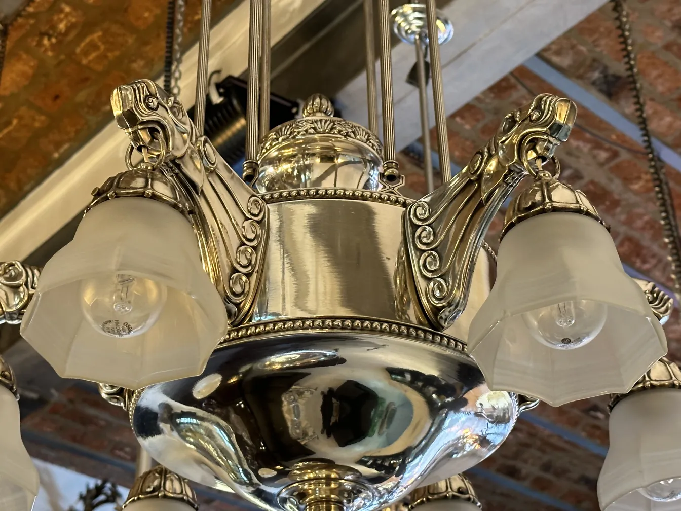 Antique hanging lamp with intricate design, featuring flower-shaped shades in a cozy setting.