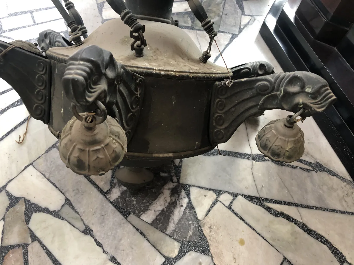 고전적인 분위기의 장식적인 양각 세부사항이 있는 교수형 램프.