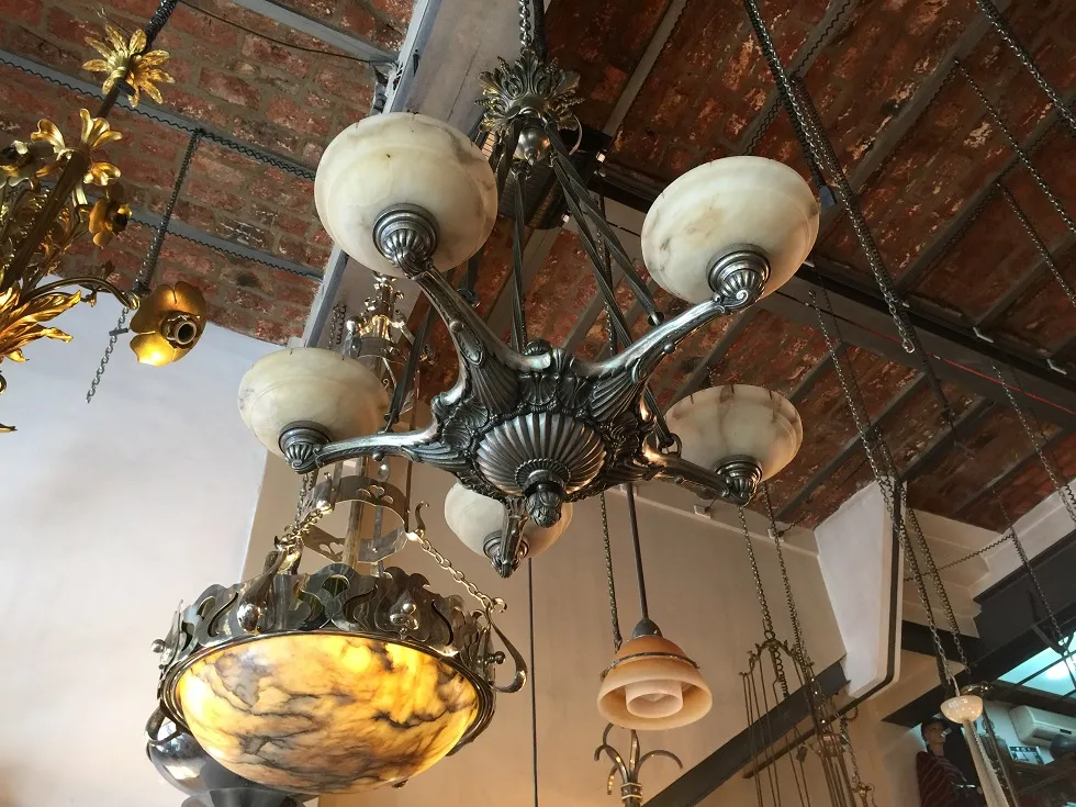 Lámpara de techo antigua con cúpulas esféricas y detalles decorativos. Ambiente de estilo clásico.