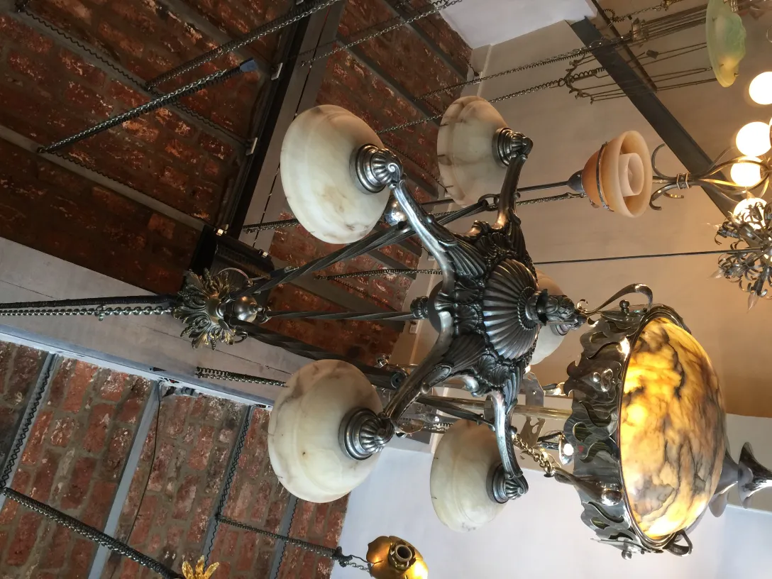 Lampada a sospensione antica con lampade sferiche e dettagli delicati, ideale per l'ambientazione.