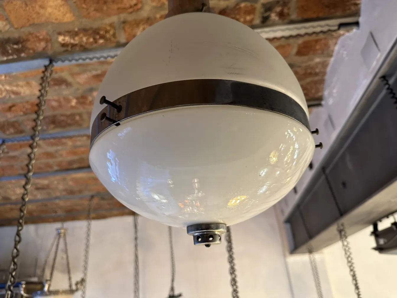 Lámpara de techo antigua con diseño esférico en cristal, colgando del techo.