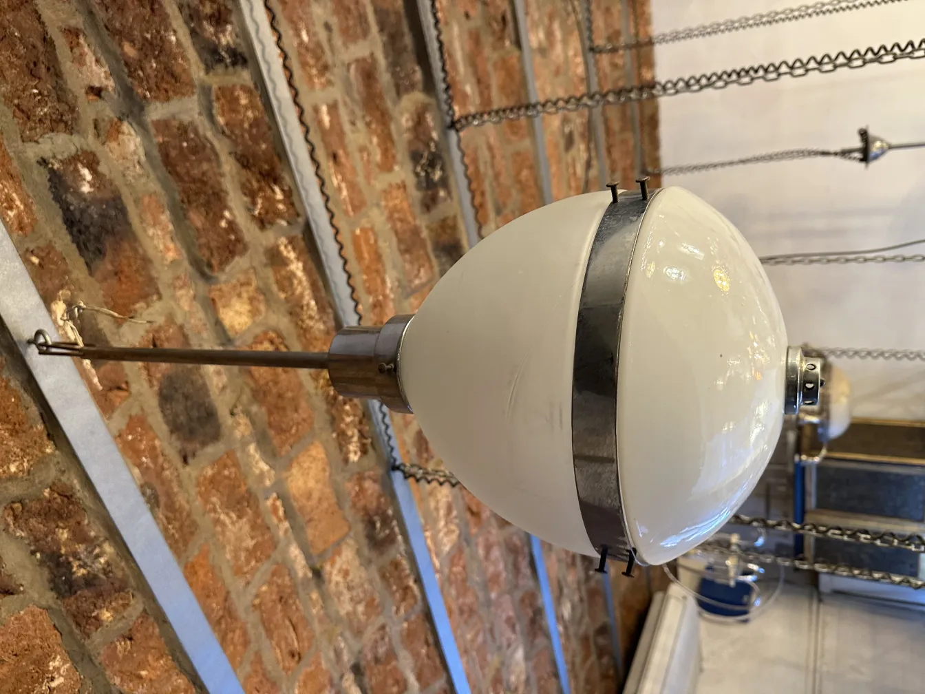 Lámpara de techo antigua con esfera blanca, ambiente cálido y acogedor.