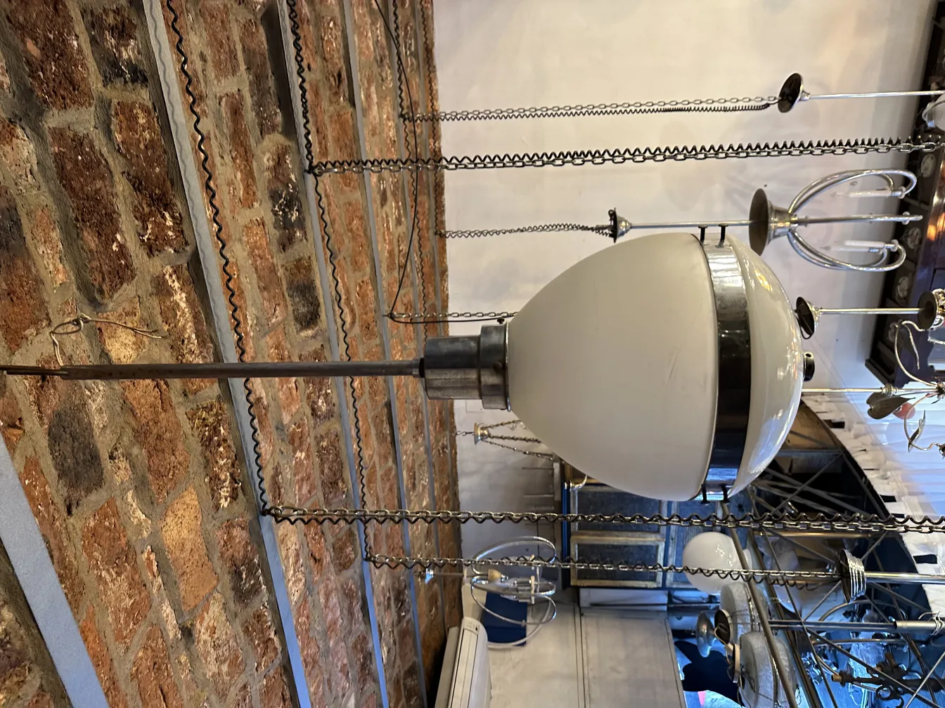 Lámpara de techo antigua en un ambiente contemporáneo, con base metálica y pantalla blanca.