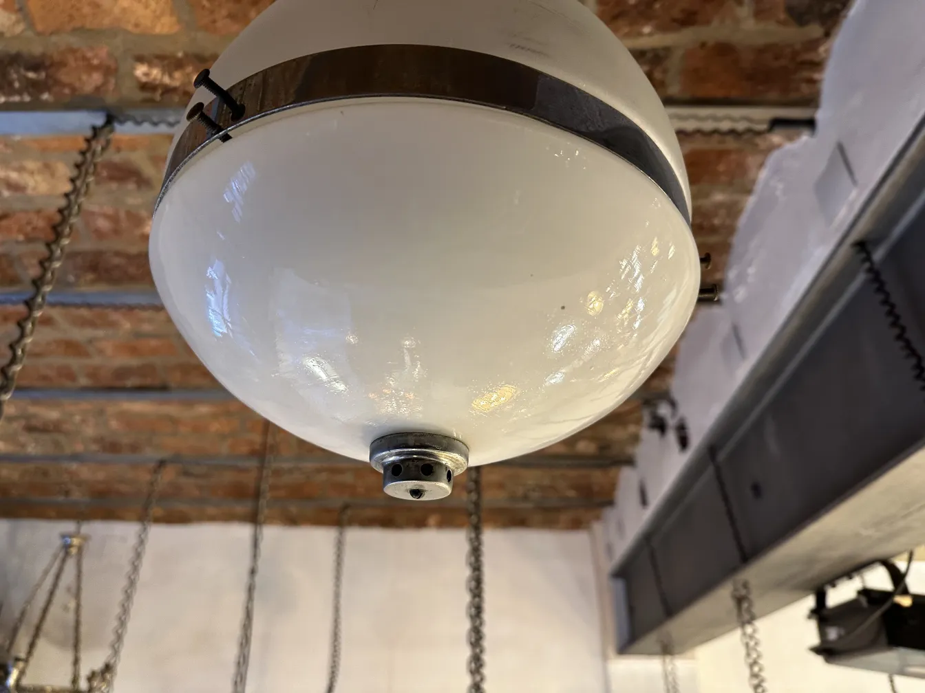 Lampada a sospensione antica bianca con dettagli metallici in un ambiente accogliente