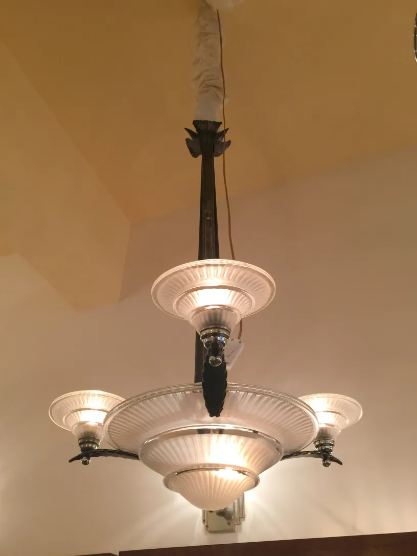 Lustre ancien au design distinctif et lumières chaleureuses, ambiance accueillante.