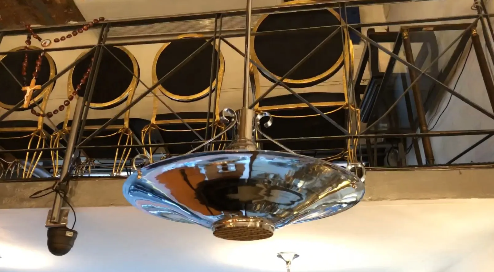 Shiny antique hanging lamp, part of a decor. Golden chairs in the background.