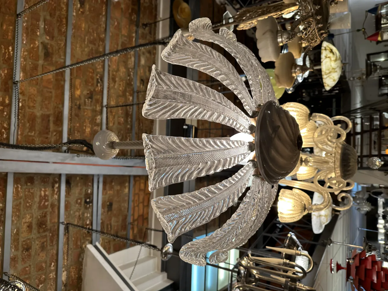 Lustre antique avec un design en forme de feuilles, exposé dans un cadre d'antiquités.