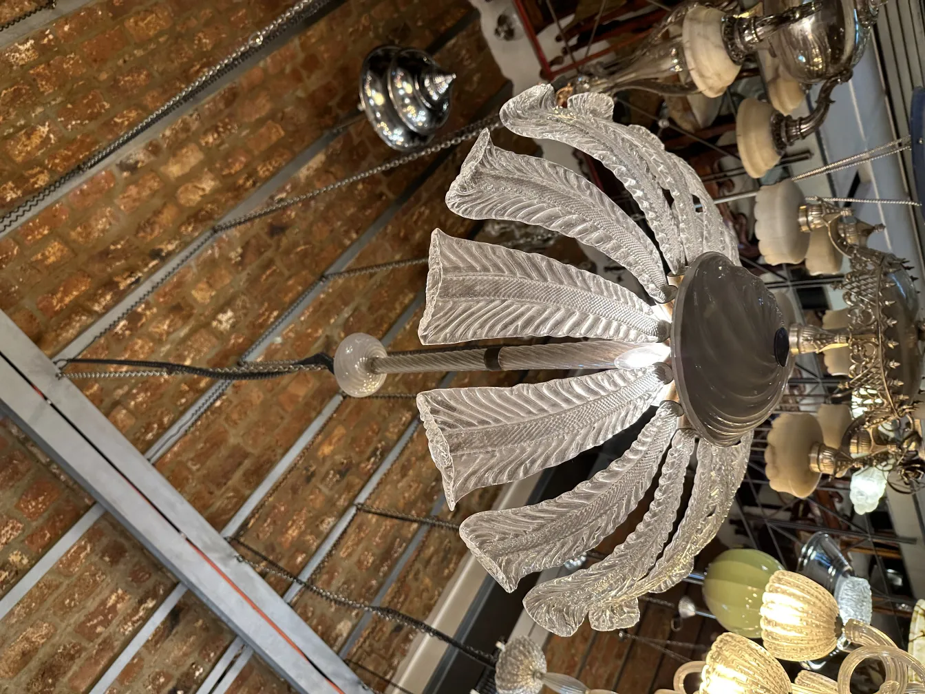 Lustre ancien avec design en verre et structure élégante dans un cadre rustique