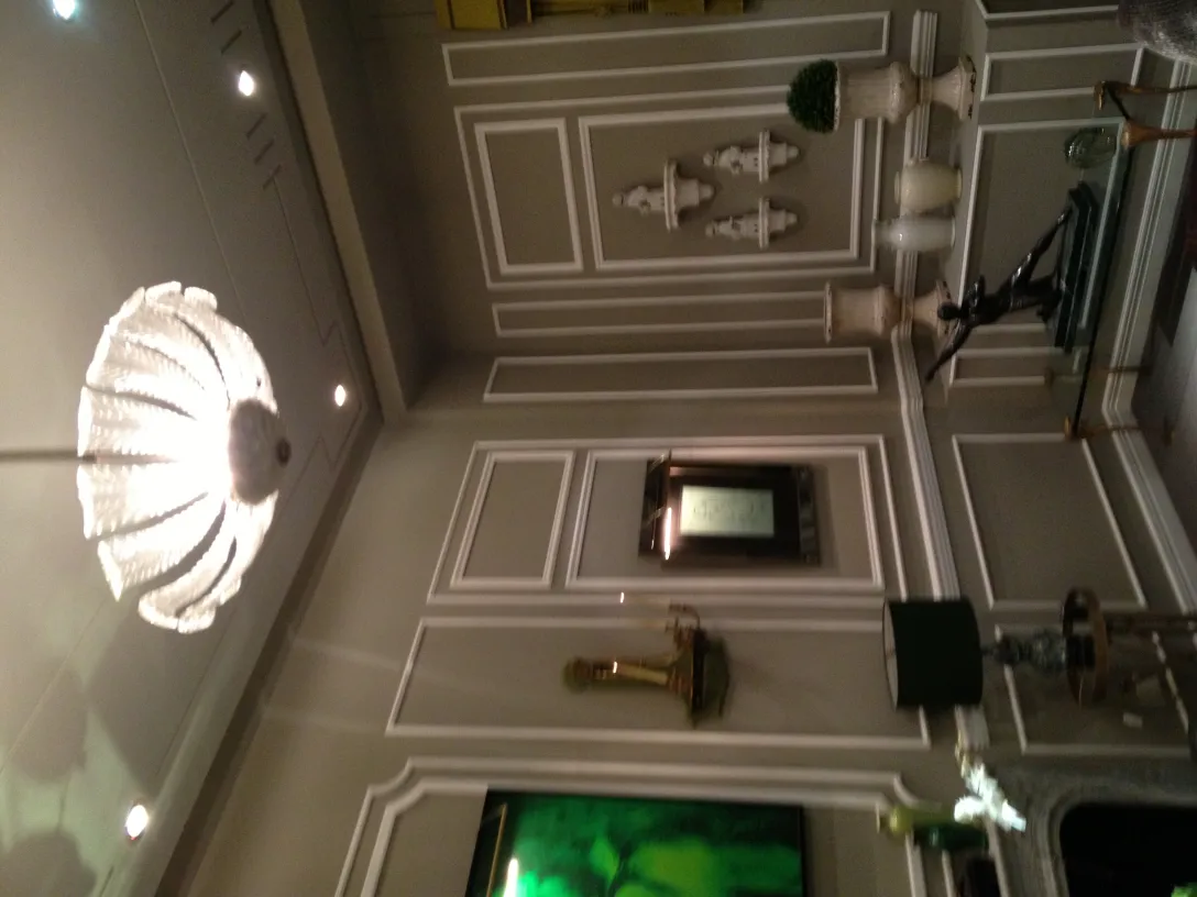 Lustre ancien avec des décorations délicates, dans un cadre élégant.