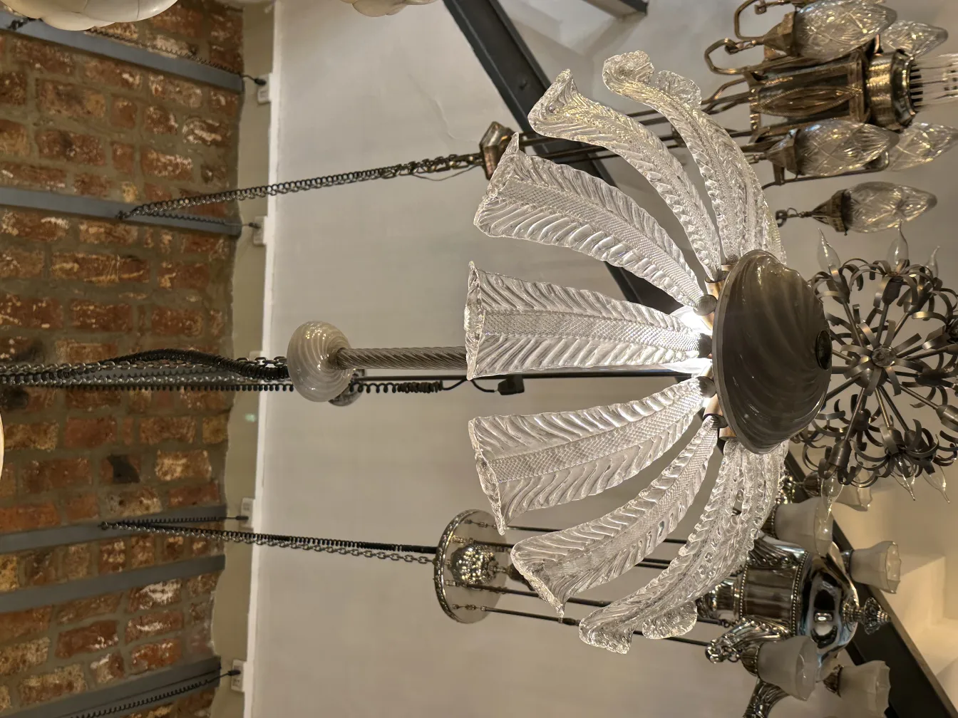 Lustre ancien avec un design en verre complexe, créant une atmosphère chaleureuse.