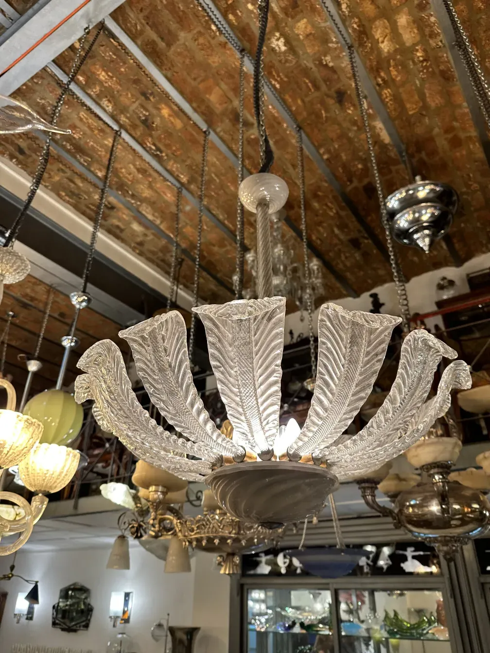 Antique hanging lamp design, paolo venini style, in a decorative setting with bright lights.