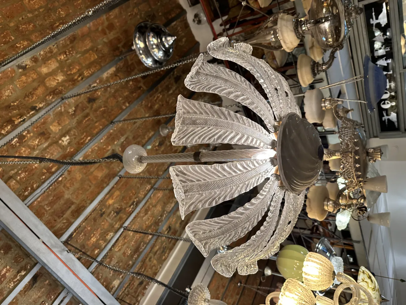 Antique hanging lamp with ornamental design in a retro setting with exposed bricks.