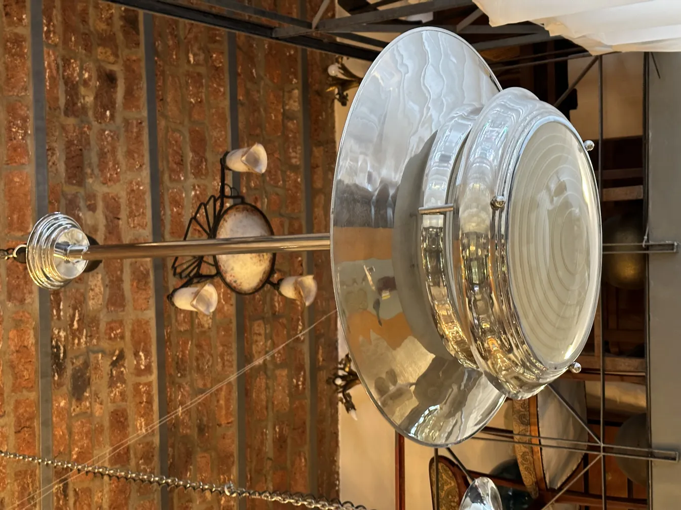 Lâmpada de teto antiga com design brilhante em ambiente rústico.