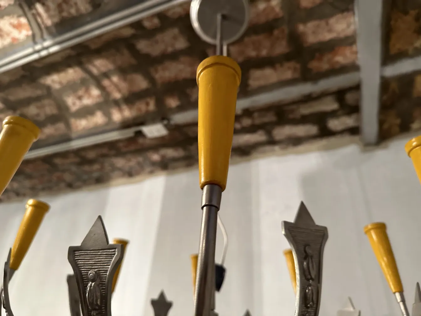 Lâmpada de teto antiga com detalhes amarelos, iluminando um espaço aconchegante.