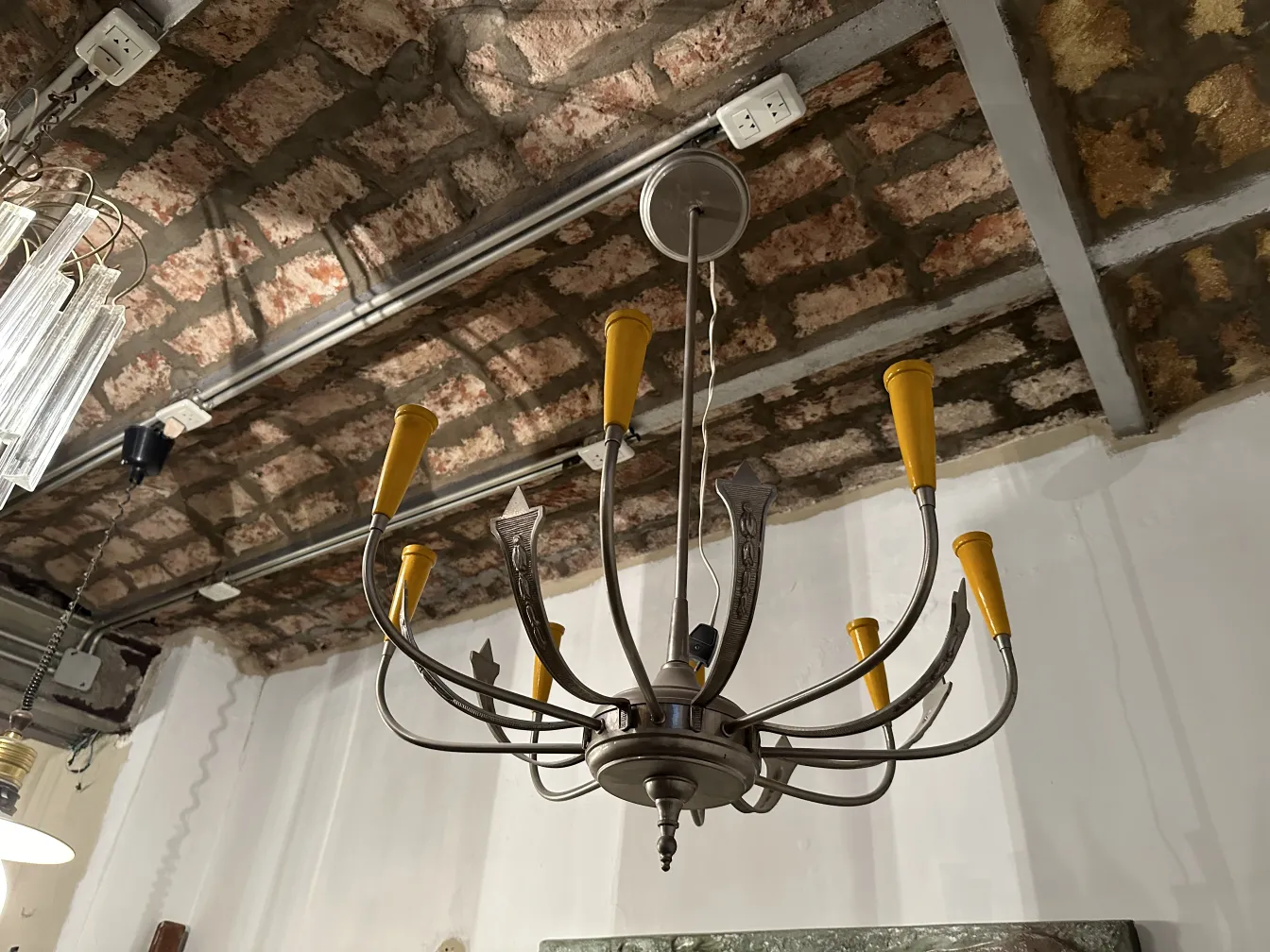 Antique hanging lamp with six yellow arms, in a vintage setting.