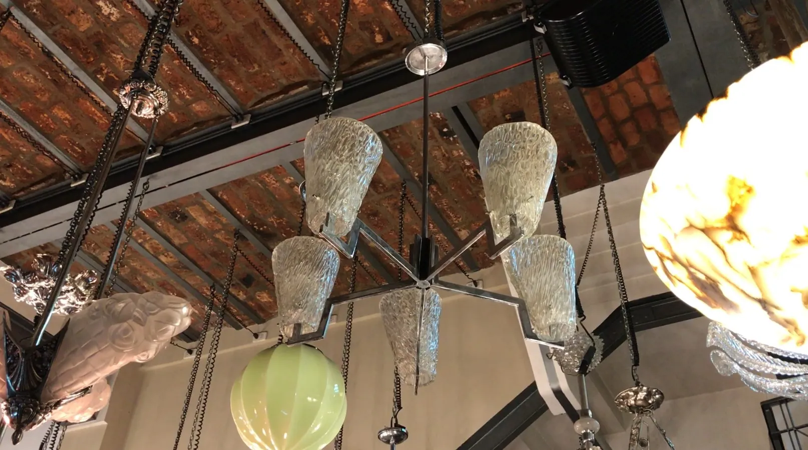 Lustre antique avec différents abat-jours en verre dans un cadre contemporain.