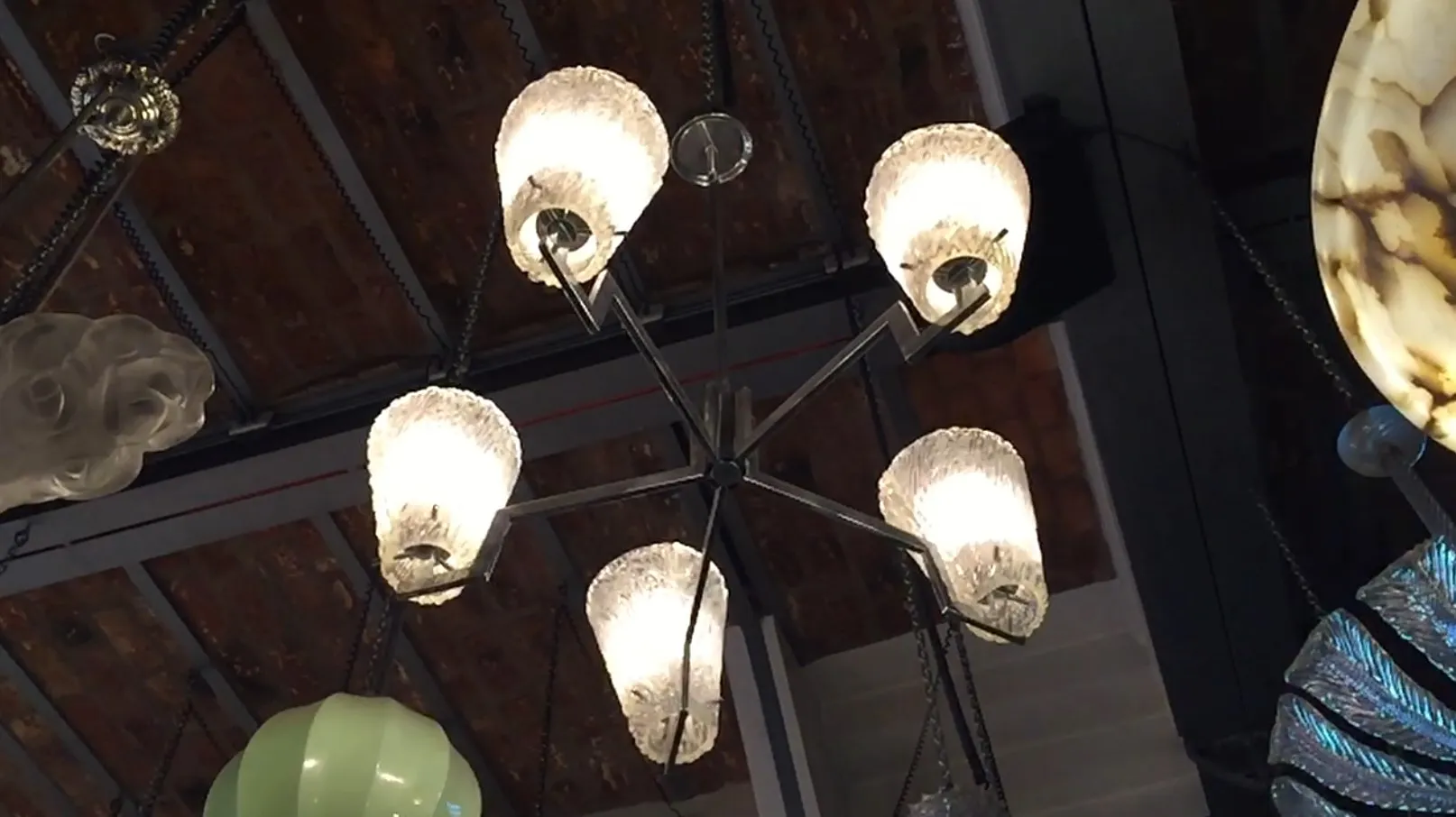 Lámpara de techo antigua con colgantes de cristal y luz suave.