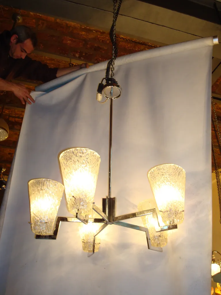 Lustre antique avec cinq lumières brillantes, créant une ambiance chaleureuse.