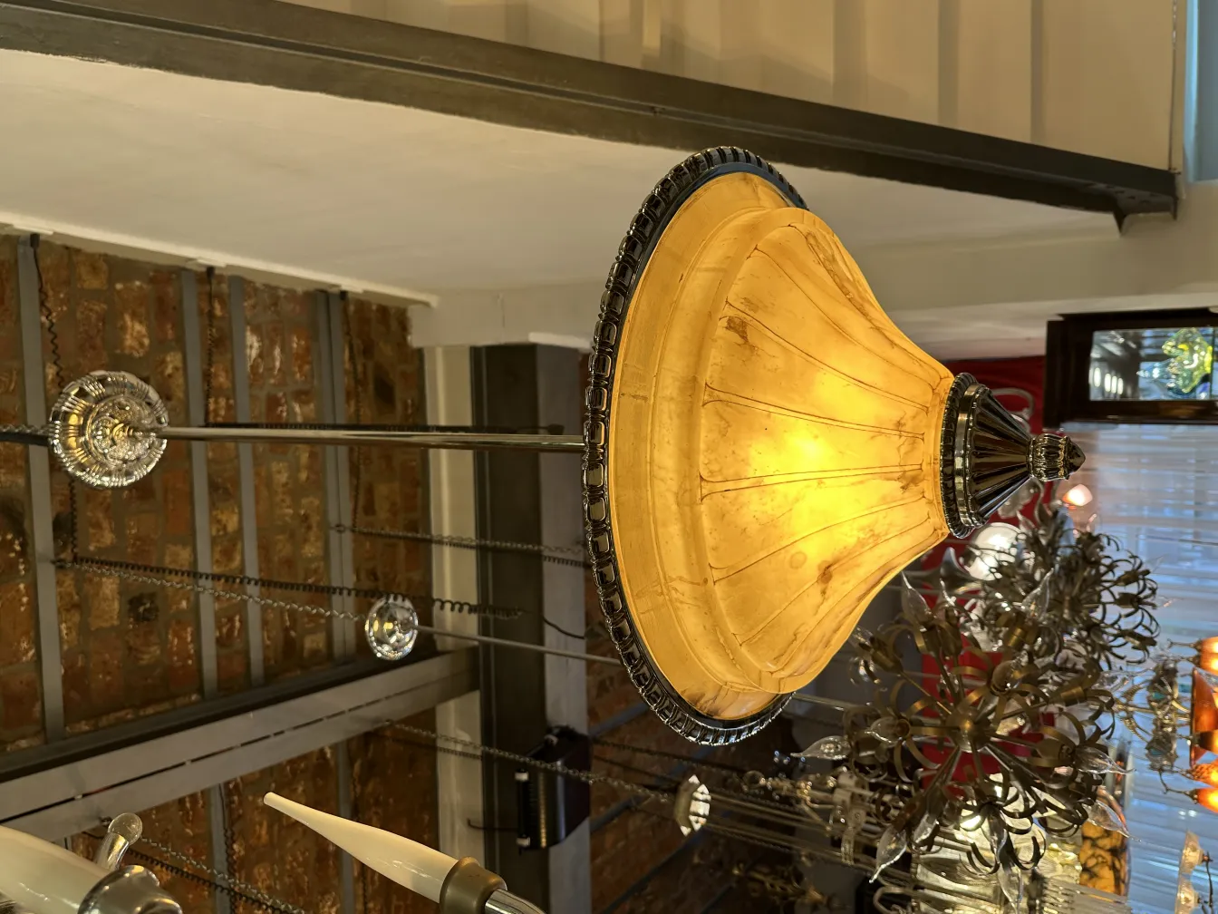 Lampada a sospensione antica con paralume dorato e dettagli eleganti, atmosfera accogliente.