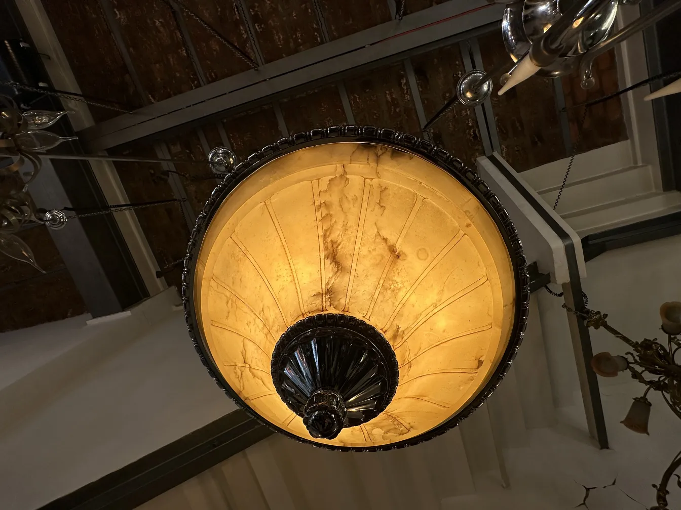 Lâmpada de teto antiga com luz suave em ambiente elegante.