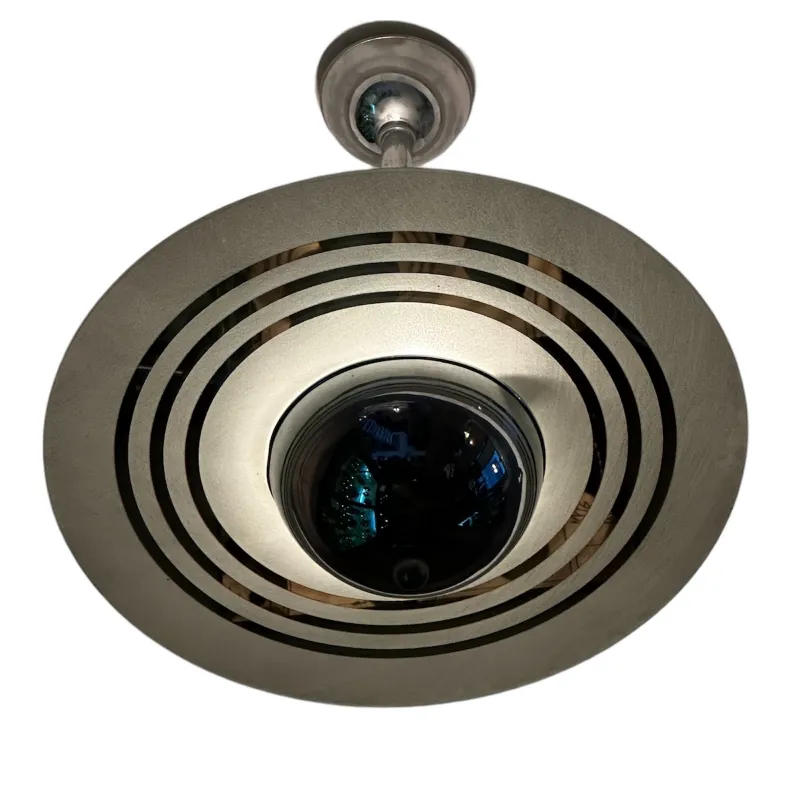 Lámpara de techo antigua con diseño circular y luz suave.