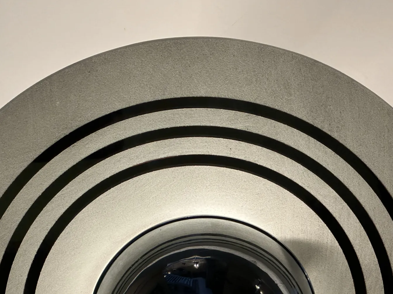 Lampada a sospensione antica con design circolare elegante in un ambiente minimalista.