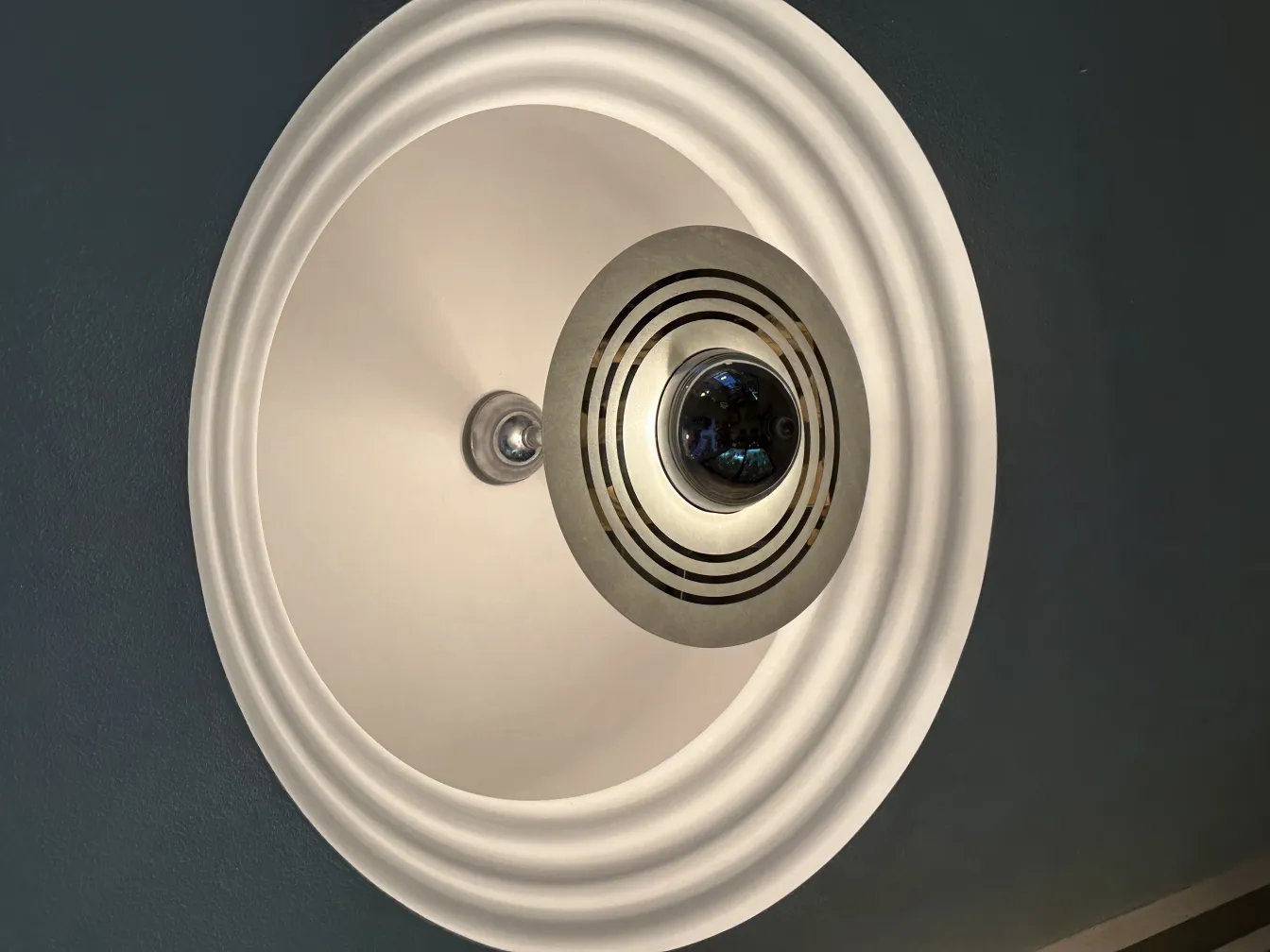 Lampada a sospensione antica in un ambiente moderno con dettagli sottili.